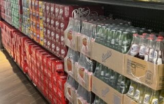 Grocery store soda aisle with various brands.