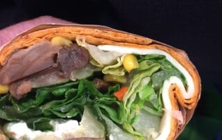 Close-up of veggie and meat wrap.